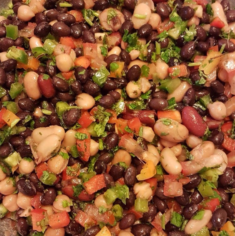 Large bowl of four bean salad with lots of vegetables.