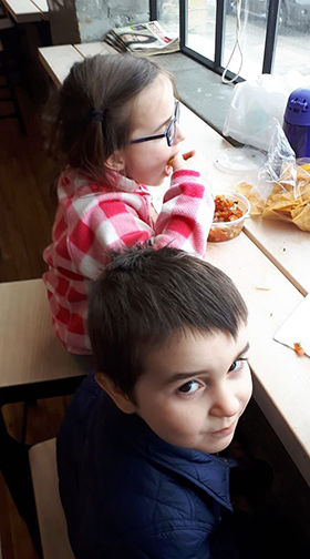 Little boy and girl snacking on salsa.