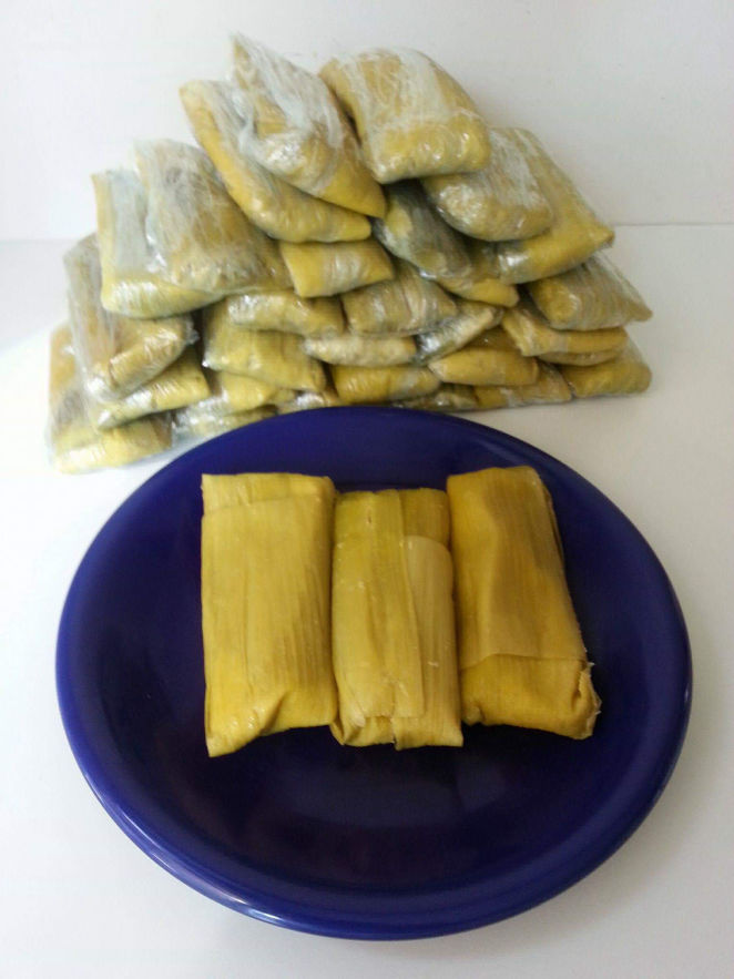 Corn tamales on a plate and in background.