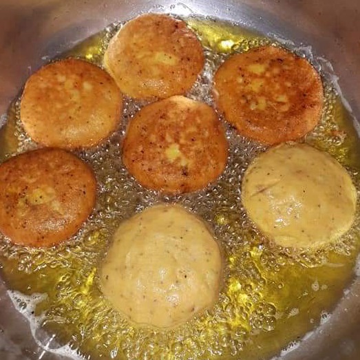 Tortita de papa being lightly fried until golden.